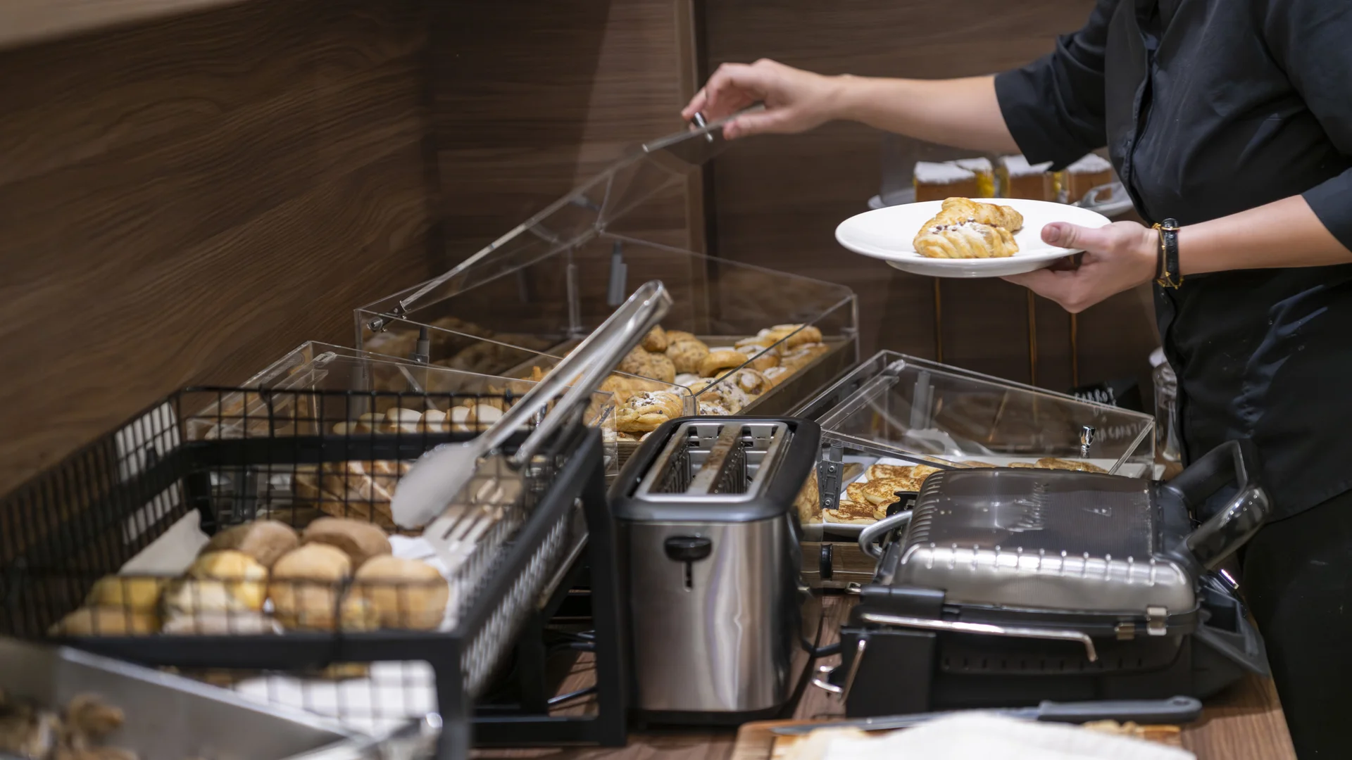 Hotel Touring in Verona | Picture gallery Persona che prende un cornetto da un buffet con tostapane e piastra