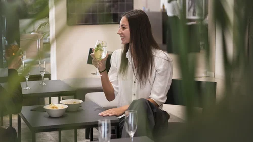 Hotel Touring in Verona | Picture gallery Donna che sorseggia una bevanda in un bar con tavoli e snack