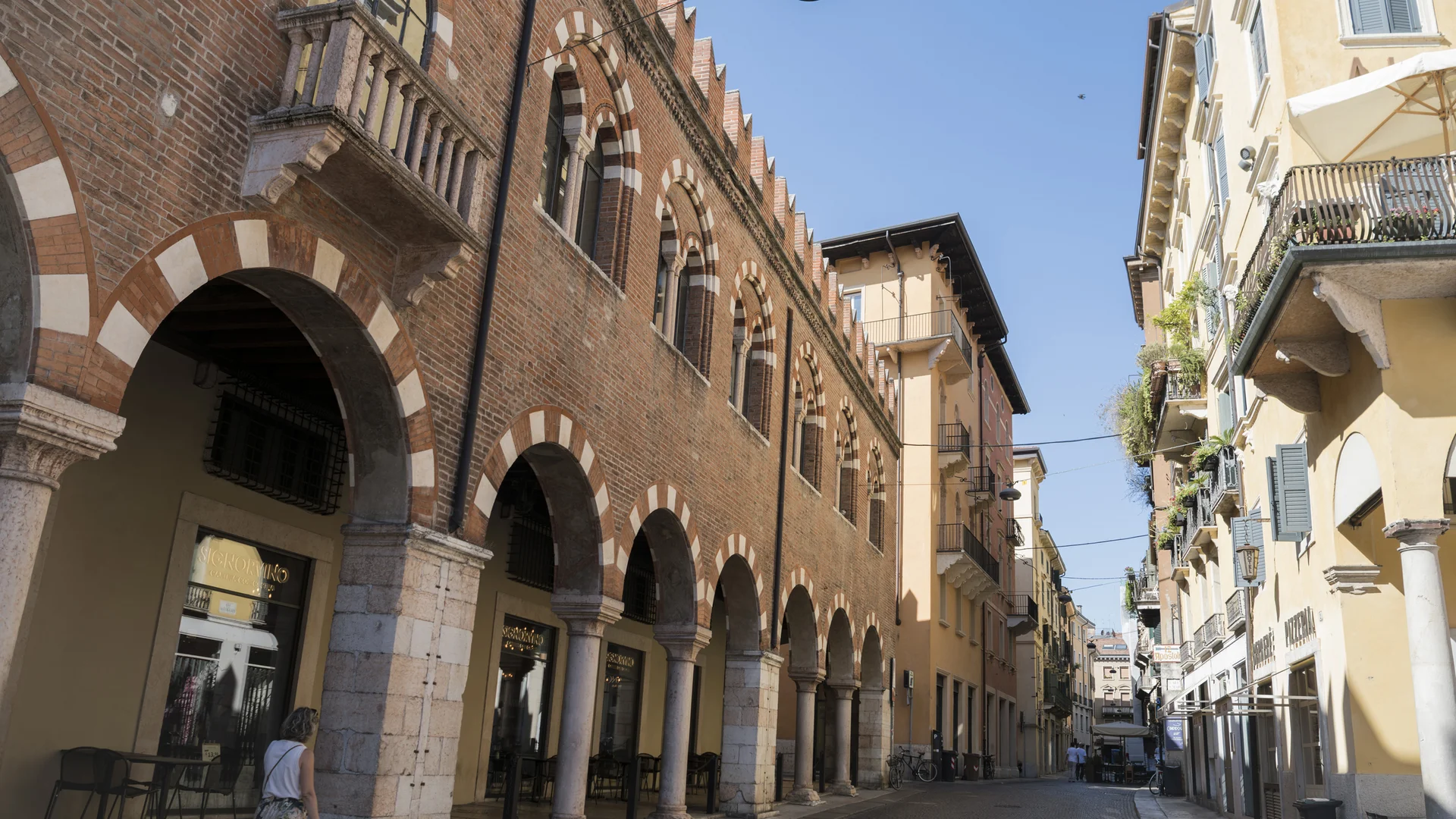 Hotel Touring in Verona | Picture gallery Strada con portici e edifici storici in mattoni sotto un cielo azzurro