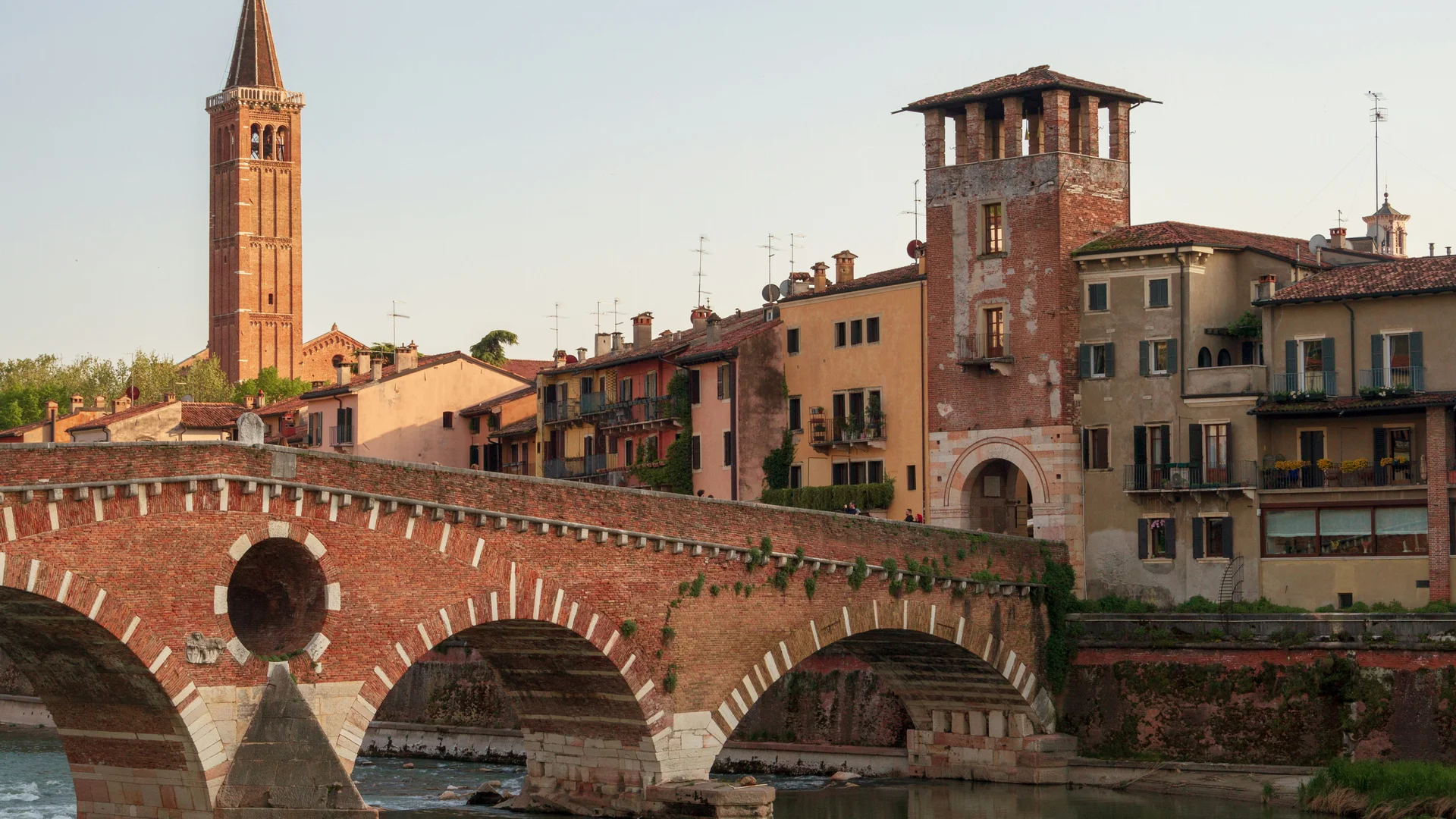 Hotel Touring in Verona | Picture gallery Stone bridge and historic houses along the river at sunset