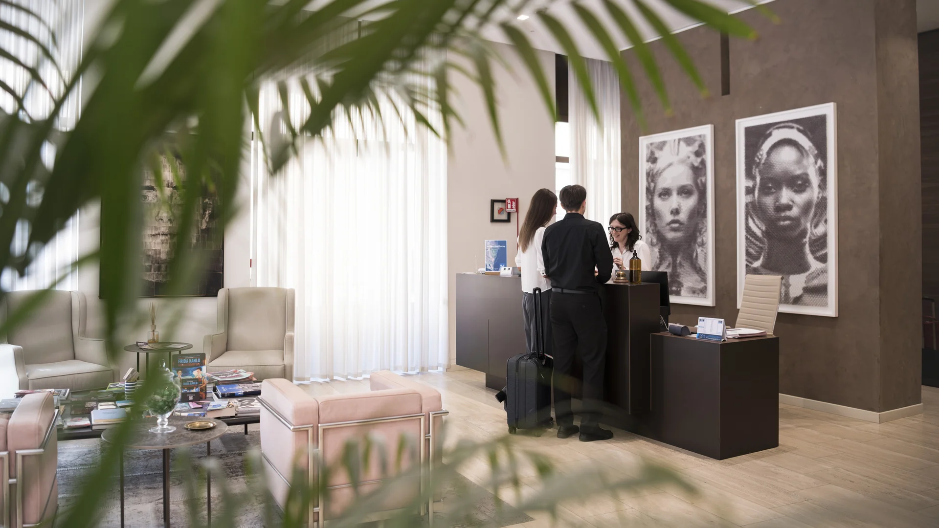Hotel Touring in Verona | Picture gallery Reception di hotel con due ospiti al banco e arredi moderni