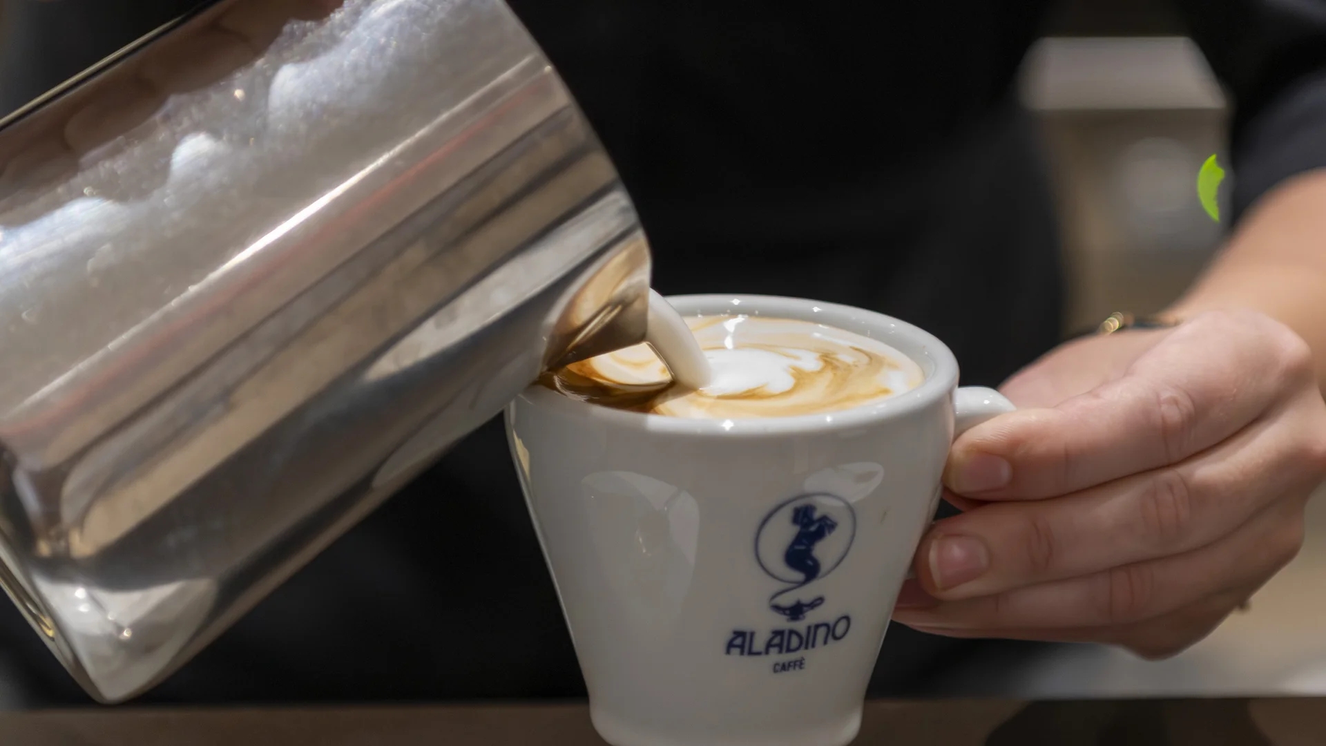 Hotel Touring in Verona | Picture gallery Barista che versa latte in una tazza di caffè per preparare un cappuccino