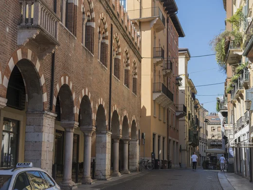 Strada con archi in pietra e edifici storici in una città italiana