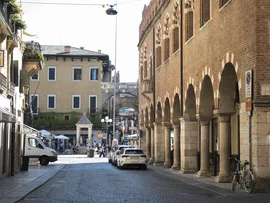Strada con portici e archi in mattoni in una città italiana soleggiata