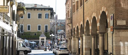 Strada con portici e archi in mattoni in una città italiana soleggiata