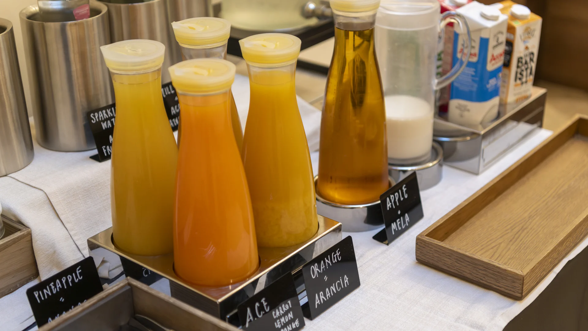 Hotel Touring in Verona | Picture gallery Bottiglie di succhi di frutta etichettati su un tavolo con tovaglia bianca