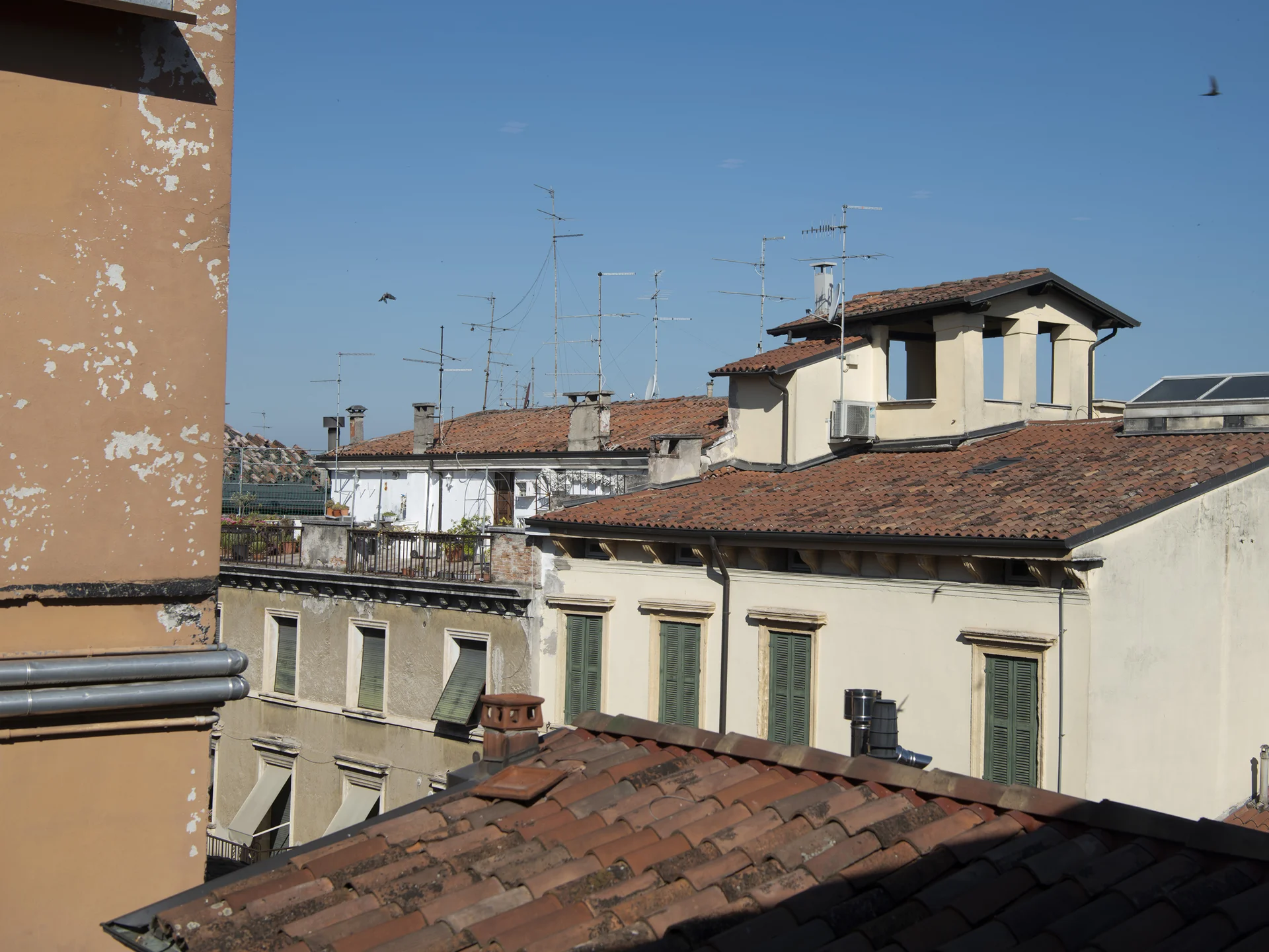 Hotels near the Arena di Verona, Italy | Touring Veduta di tetti e antenne su edifici residenziali sotto un cielo azzurro