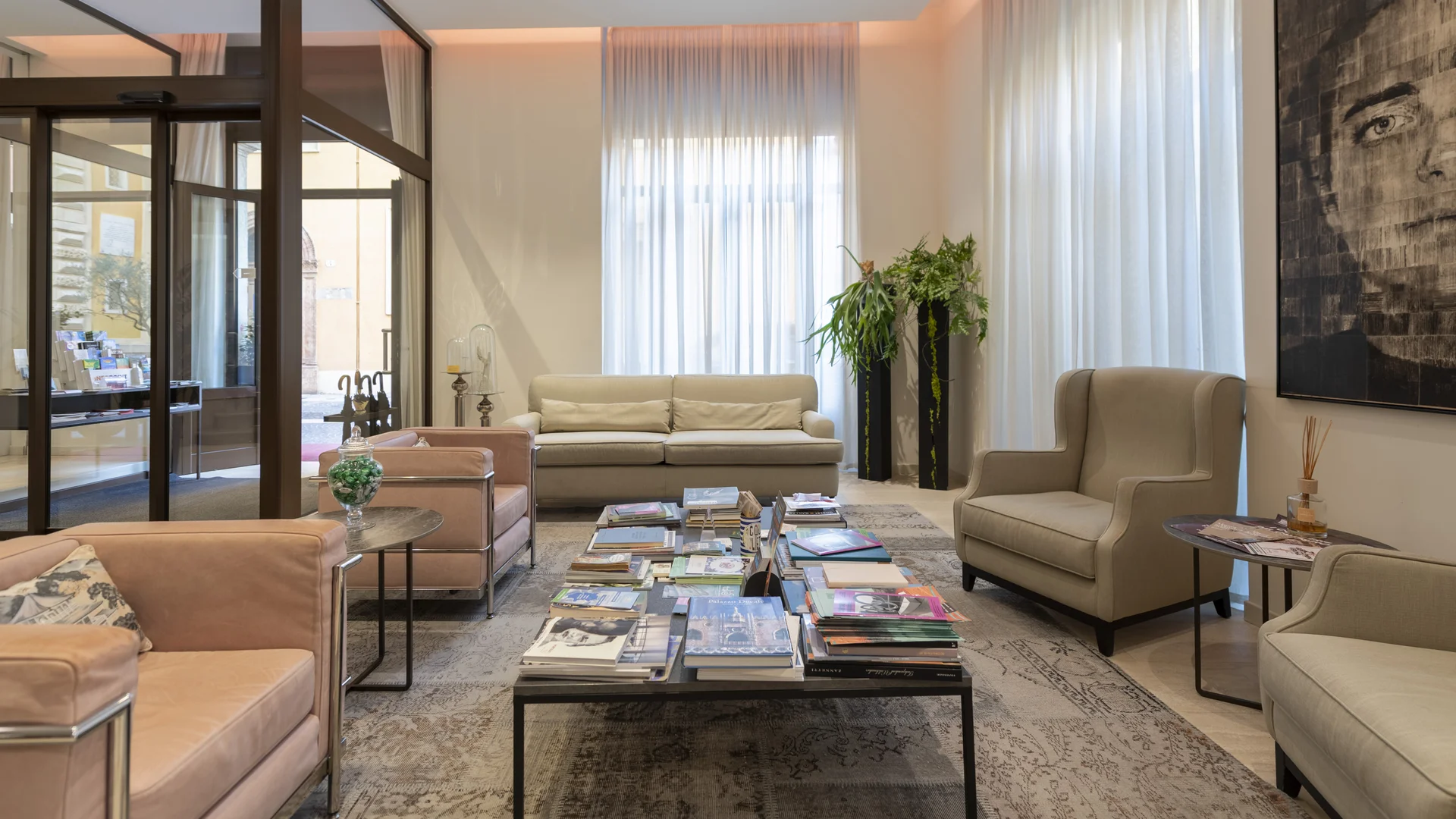 Hotel Touring in Verona | Picture gallery Sala d'attesa elegante con divani, poltrone e tavolo con libri e riviste