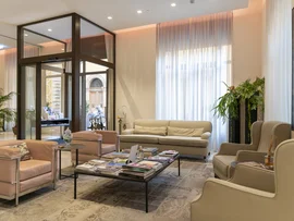 Salotto elegante con divani, poltrone e tavolino con riviste in hotel